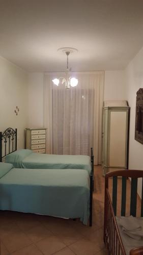a bedroom with two beds and a chandelier at Villa Malandrino Guest House in Agropoli