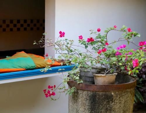 a planter with flowers in it next to a bed at Villa Samithru, Wadduwa in Wadduwa