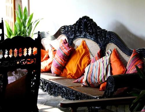 a black couch with colorful pillows on it at Villa Samithru, Wadduwa in Wadduwa