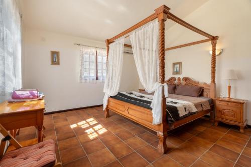 a bedroom with a canopy bed and a wooden floor at 3-bedroom Villa in Golf del Sur in San Miguel de Abona