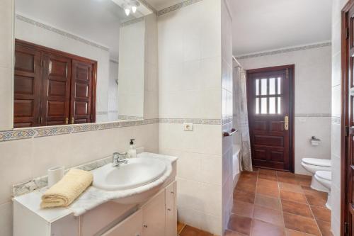 a white bathroom with a sink and a toilet at 3-bedroom Villa in Golf del Sur in San Miguel de Abona