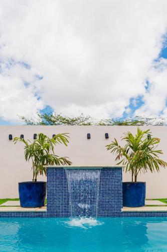 a swimming pool with two palm trees next to a building at Lord's Suites in Cura Cabai