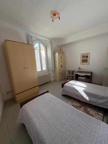 a bedroom with two beds and a dresser and a window at I Rimarici in Pavia