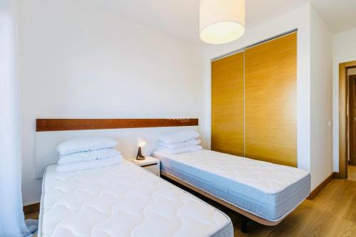 a bedroom with two beds and a wooden headboard at Ocean Green Retreat Lagos in Lagos
