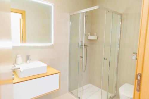 a bathroom with a shower and a sink at Ocean Green Retreat Lagos in Lagos