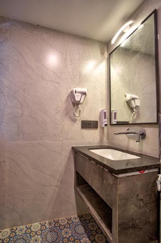a bathroom with a sink and a mirror at Hotel Dimaru Boutique in Calangute
