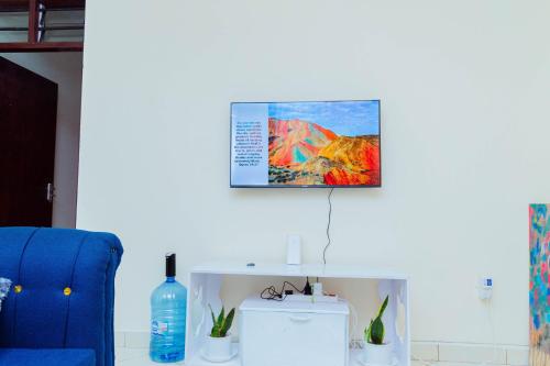 a room with a blue chair and a picture on the wall at Frank's Homes in Kwale