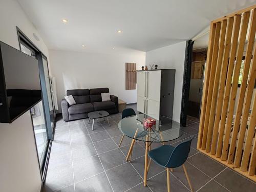 a living room with a couch and a glass table at LEntre-Deux Week-ends in Cléguer