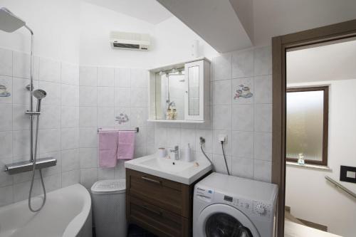 a bathroom with a sink and a washing machine at Ferienhaus Captains in Vintijan