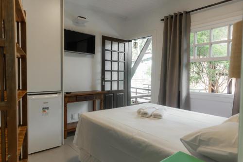 a bedroom with a bed with two towels on it at Pousada Bellissima in Boicucanga