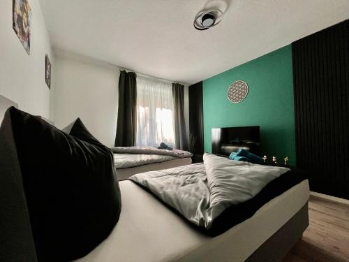 Un dormitorio con dos camas y una pared verde. en Living dream in Halle, en Halle an der Saale