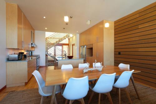 a kitchen and dining room with a wooden table and white chairs at ALOFT Airy Design with River View in Hood River