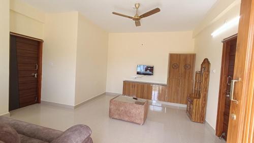 a living room with a couch and a ceiling fan at Sree Vishnu Homestay in Tirupati