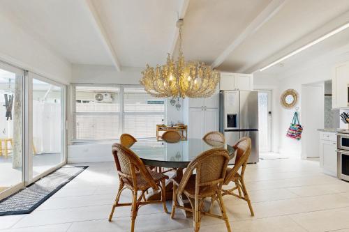 a dining room with a table and chairs and a chandelier at Carpe Diem - Seas The Day in Key Colony Beach