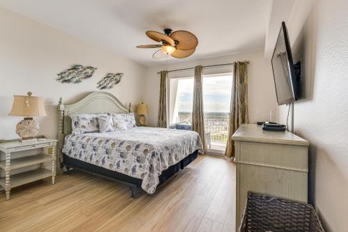 Un dormitorio con una cama y un televisor y una ventana. en Comfy PCB Condo with View and Private Beach Access!, en Panama City Beach