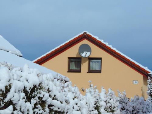 リプトフスキー・ミクラーシュにあるHoliday Home Lindaの雪が積もった屋根に時計がある家