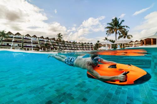 a man in the water on an orange raft in the swimming pool at Grand Velas Riviera Maya - All Inclusive in Playa del Carmen