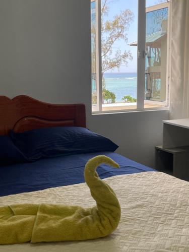 a swan is laying on a bed in a bedroom at Spacious 3 bed seaview apartment in Flic-en-Flac