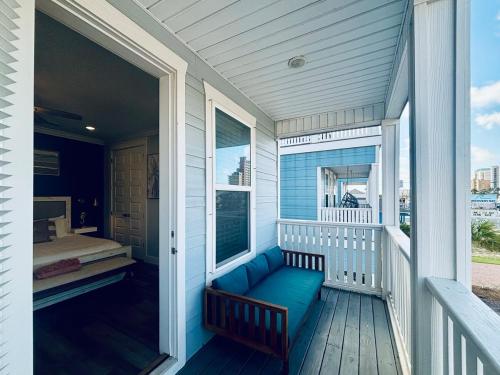 Un porche con un sofá azul y una cama encima. en Spacious Beach Retreat with Deck, Arcade & Easy Beach Access, en Panama City Beach