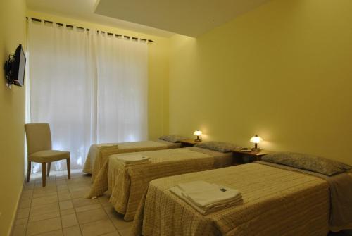 pokój hotelowy z 3 łóżkami i oknem w obiekcie Roma Tourist House w Rzymie