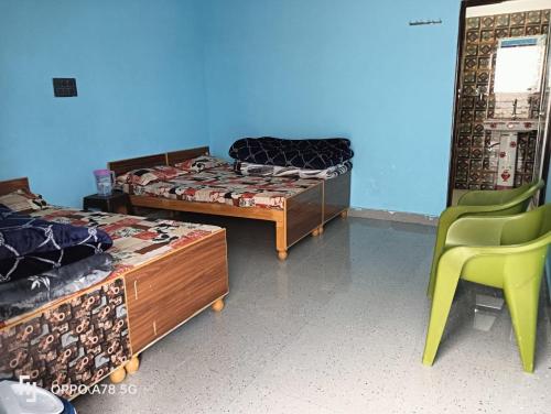 a room with three beds and a green chair at Panchkedar resort in Sonprayag