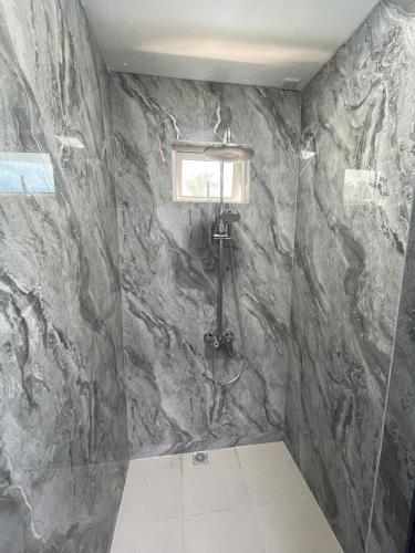 a bathroom with a shower with a stone wall at Spacious 3 bed seaview apartment in Flic-en-Flac