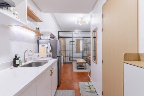 a kitchen with white cabinets and a sink at 1BR Condo with Free Parking at SMDC Trees Residences, Fairview Quezon City in Manila