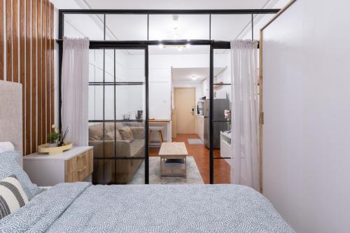 a bedroom with a bed and a living room at 1BR Condo with Free Parking at SMDC Trees Residences, Fairview Quezon City in Manila