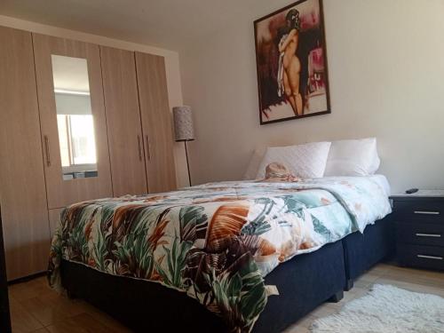 ein Schlafzimmer mit einem Bett mit einer bunten Decke in der Unterkunft Habitación confortable cama doble Ibagué in Ibagué