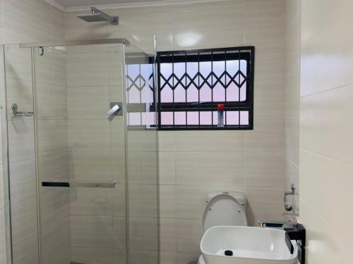 ムババーネにあるS'hlahla Apartmentsのバスルーム(シャワー、トイレ付)、窓が備わります。