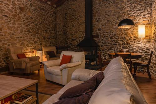 a living room with a couch and chairs and a table at 1703 CHAMBRE ET TABLE D'HOTES in Angoustrine