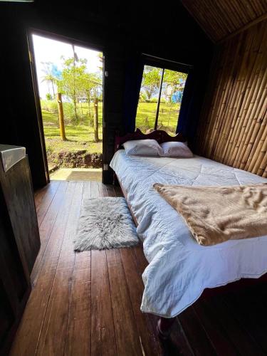 a bedroom with two beds in a room with a window at Cabinas los Jilgueros in San Vito