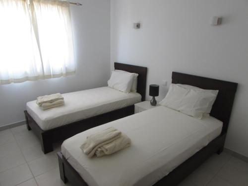 a bedroom with two beds with towels on them at BCV Private 2 Bed Apartment with Pool View Dunas Resort 7009 in Santa Maria