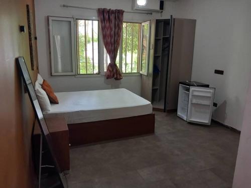 una camera da letto con un letto grande e una finestra di Appartement zone b a Dakar