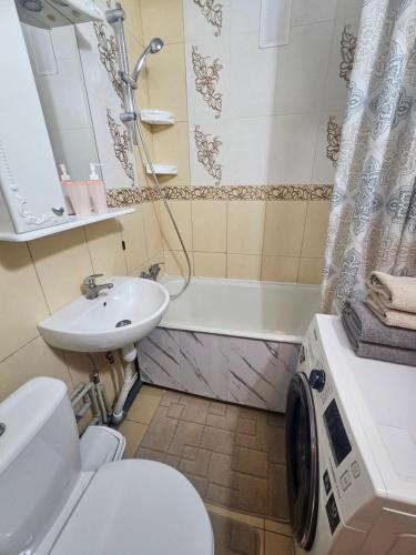 a bathroom with a sink and a toilet and a tub at Апартаменты на Новых Домах in Kharkiv