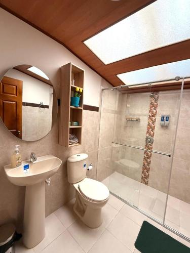a bathroom with a toilet and a shower and a sink at Hotel Villa Mercedes Colonial in Sopó