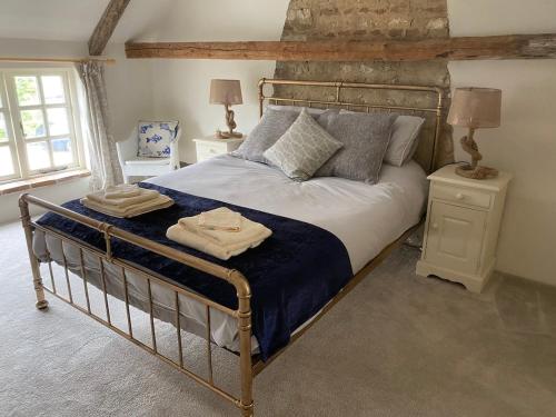 a bedroom with a large bed with blue sheets and pillows at Boutique 2 bedroom cottage - North Norfolk coast in Hindringham