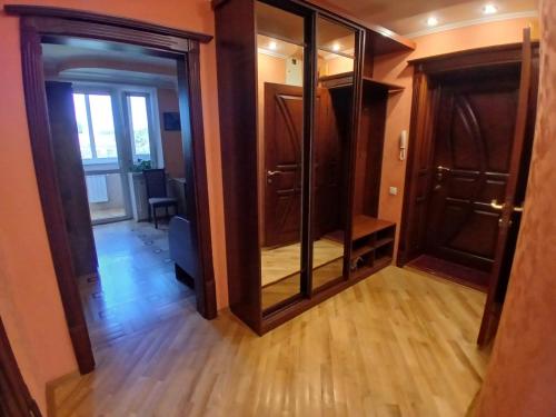 a hallway with glass doors and a room with wooden floors at Spacious apartment in the center of Vinnytsia in Vinnytsya