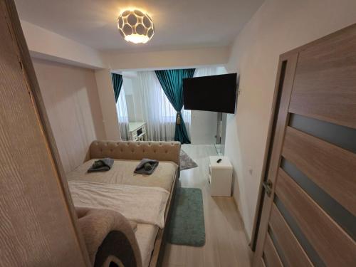 クラヨーヴァにあるLaura's Residence Luxuryのベッドと薄型テレビのある小さな部屋