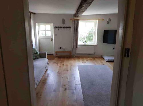 a living room with a couch and a television at Boutique 2 bedroom cottage - North Norfolk coast in Hindringham