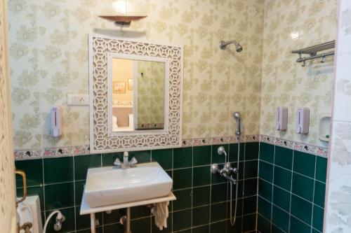 a bathroom with a sink and a mirror at 2bhk with Swimming pool & Kitchen in Candolim