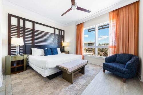 Beach Residences On Siesta, aka The Hyatt في سيستا كي: غرفة نوم بها سرير وكرسي أزرق