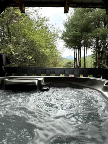 een hot tub met water en bomen op de achtergrond bij Mountain Tranquility Romantic-Hot Tub-Cabin -View in Helen