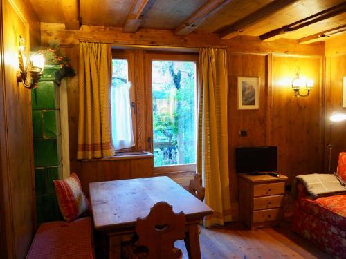 a living room with a table and a window at Courmayeur Cozy Nest in Courmayeur