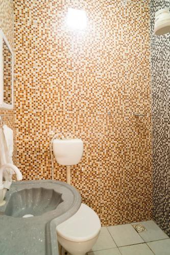 a bathroom with a toilet and a bath tub at Vila Davi Jeri - Flats e Casa in Jericoacoara
