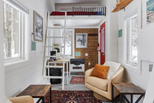 a tiny house with a loft bed and a desk at Maple Sugar Shack Tiny House with hot tub & river by Stowe in Johnson