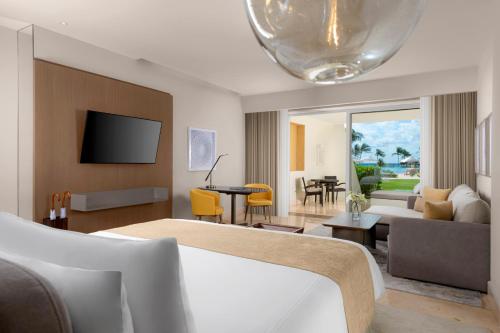 a living room with a couch and a living room with a tv at Grand Velas Riviera Maya - All Inclusive in Playa del Carmen