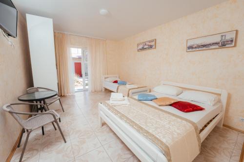 a bedroom with two beds and a table and a television at Aura in Zatoka