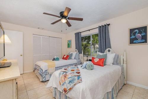 una camera da letto con due letti e un ventilatore a soffitto di Beachy Retreat - Atlas Duplex a Satellite Beach