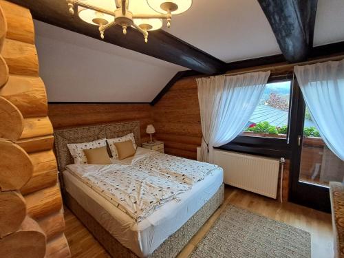 a bedroom with a bed and a large window at Pensiunea Varvara de Bucovina in Gura Humorului
